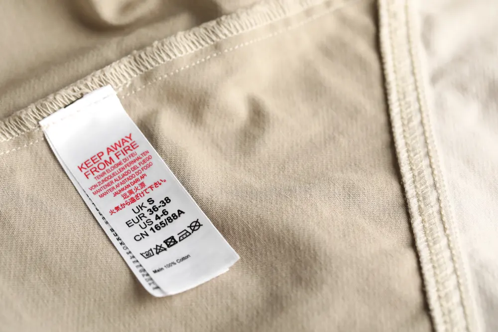 clothing-label-with-care-symbols-and-size-on-beige-2025-09-08-13-57-28-utc